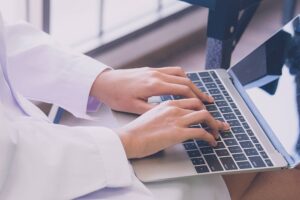 cancer registrar professional inputting patient data into a laptop at a healthcare facility