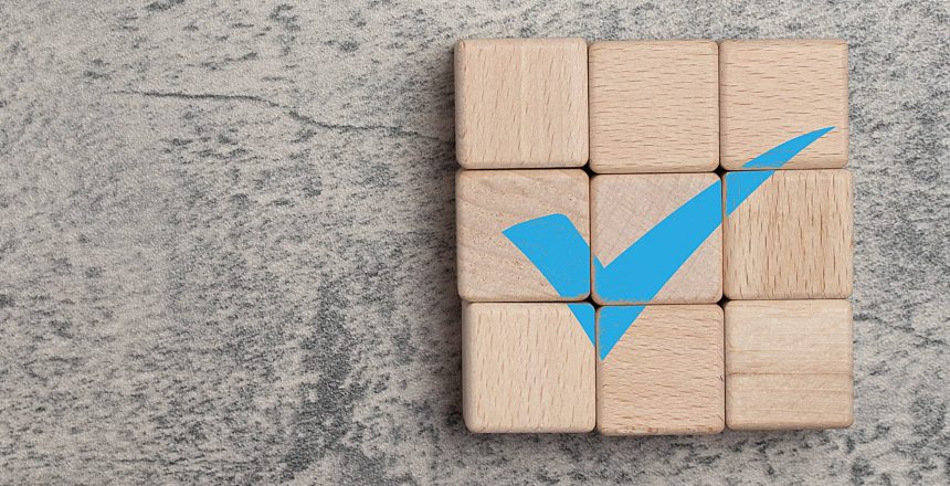 : a blue checkmark on a blocks of wood representing OIG compliance points for healthcare HIM leaders