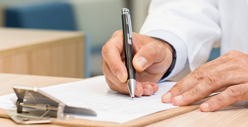 a healthcare professional in a hospital setting using a pen and clipboard reviewing social determinants of health icd-10 information